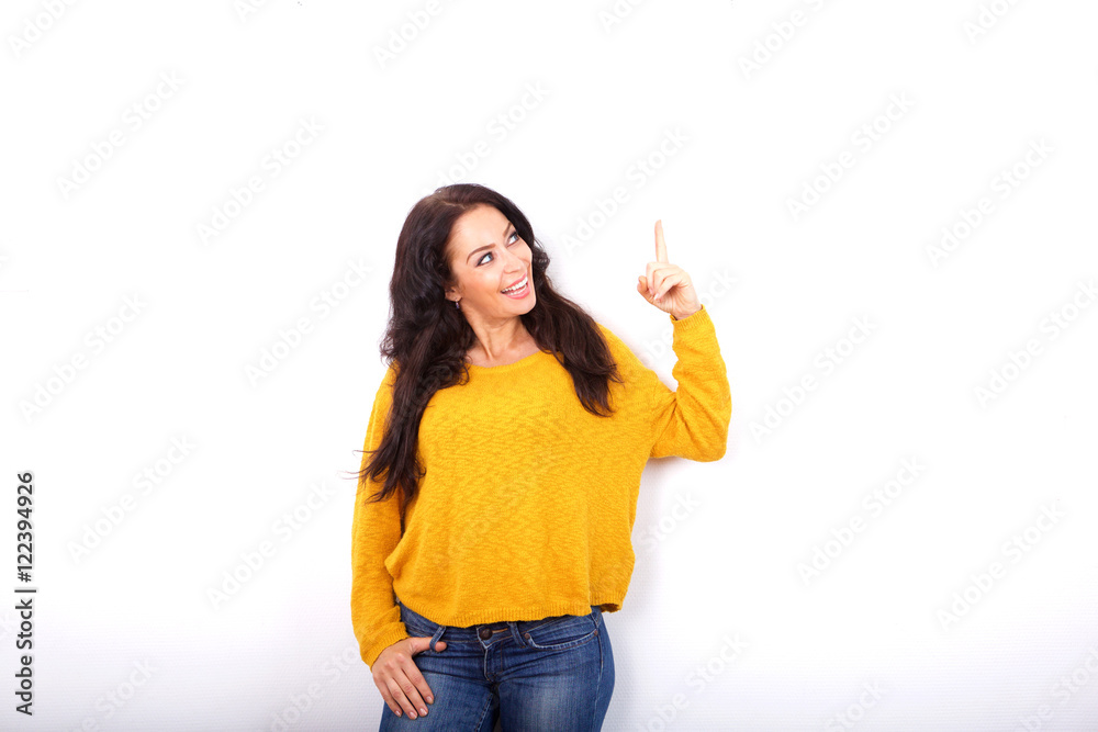 Attractive older lady pointing up on white background