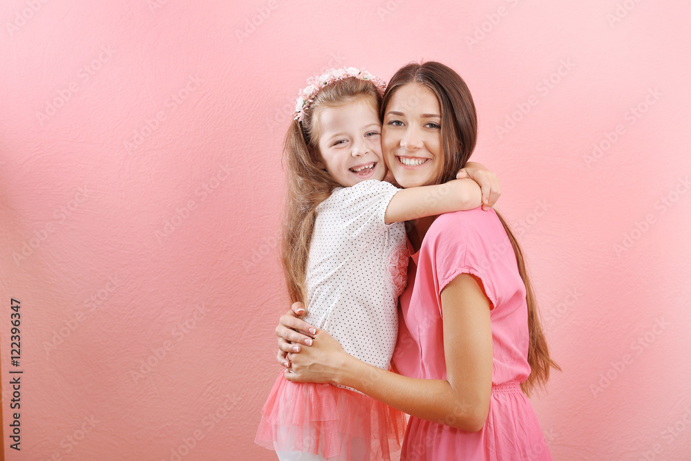 Cute girl with mother on pink wall background Cute girl with mother on pink wall background