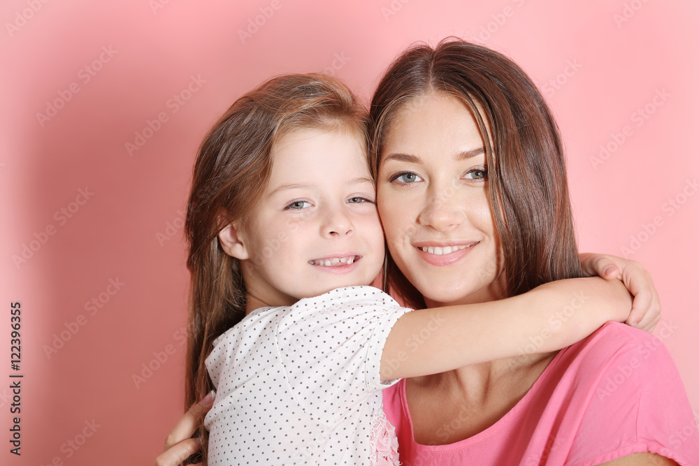 Cute girl with mother on pink wall background Cute girl with mother on pink wall background