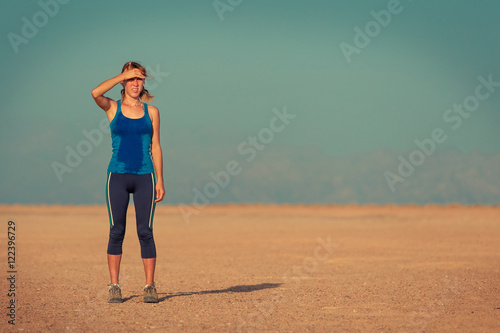 Young woman in wet clothes standing in the desert