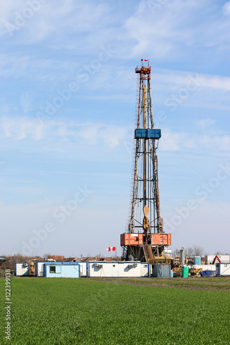 Land oil drilling rig on green field