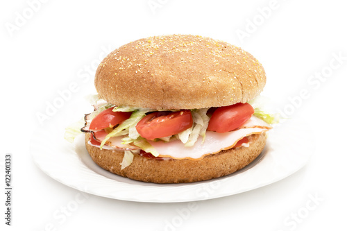 Wholemeal hamburger with ham, salad, tomatoes and mayonnaise on a white plate and background 