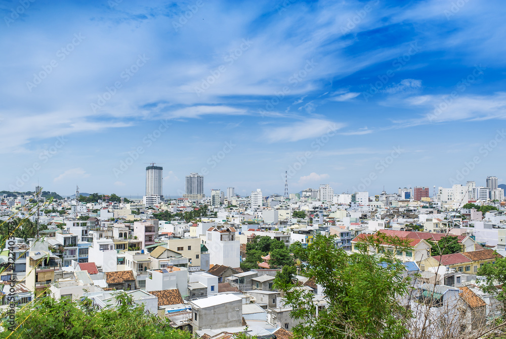 Obraz premium Bird's-eye view to buildings of the city Nha Trang in Vietnam at hot sunny day with cloudy sky