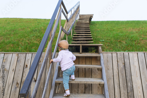 The baby climbs up a ladder into sky.