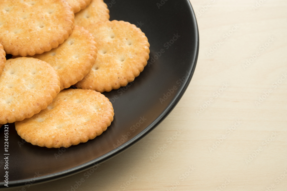 crackers cheese and crackers sugar in black plate on wood table