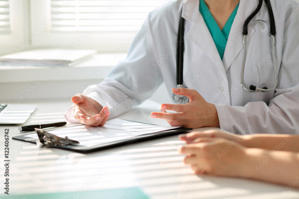 Doctor and patient are discussing something, just hands at the table Doctor and patient are discussing something, just hands at the table
