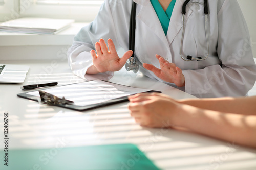 Hand of doctor  reassuring her female patient. Medical ethics and trust concept