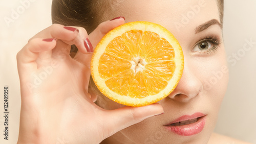 Young attractive woman with a slice of orange