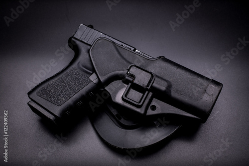 pistol in a holster in black background photo