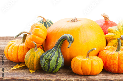pile of orange pumpkins on wooden table border isolated on white background