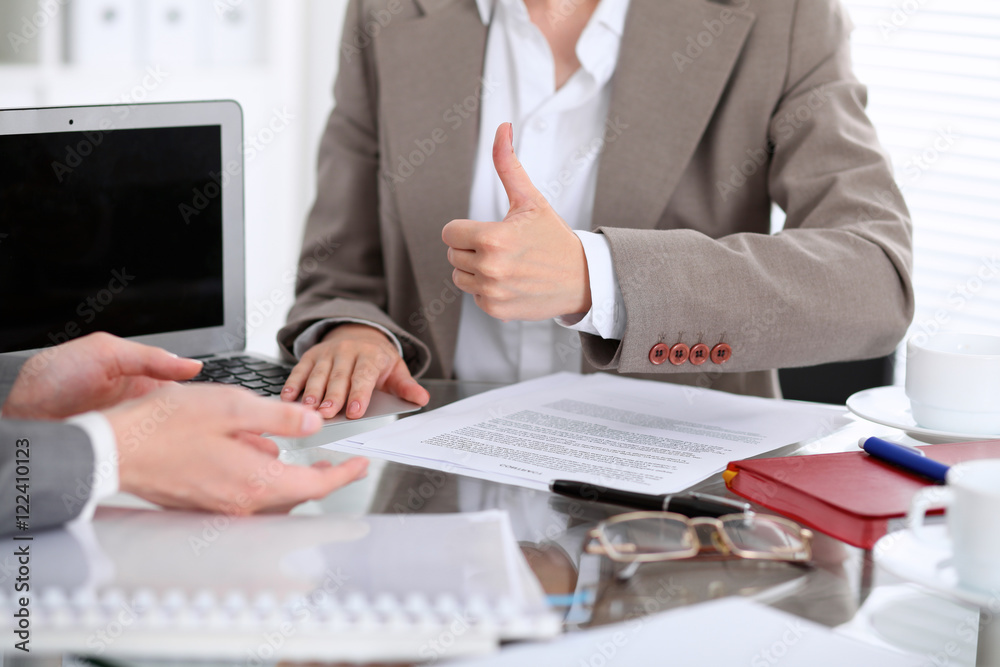 Group of business people or lawyers at meeting discussing contract papers. Woman showing thumb up Group of business people or lawyers at meeting discussing contract papers. Woman showing thumb up