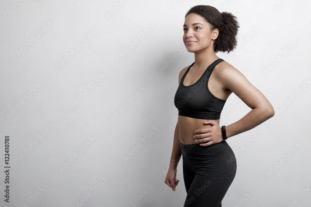 Smiling young woman in sportswear posing in studio over white background with copyspace Smiling young woman in sportswear posing in studio over white background with copyspace