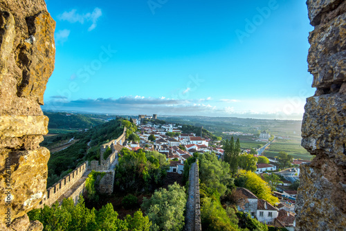 Obidos, Portugal : Cityscape of the town with medieval houses, wall and the Albarra tower. Obidos is a medieval town still inside castle walls, and very popular among tourists. photo