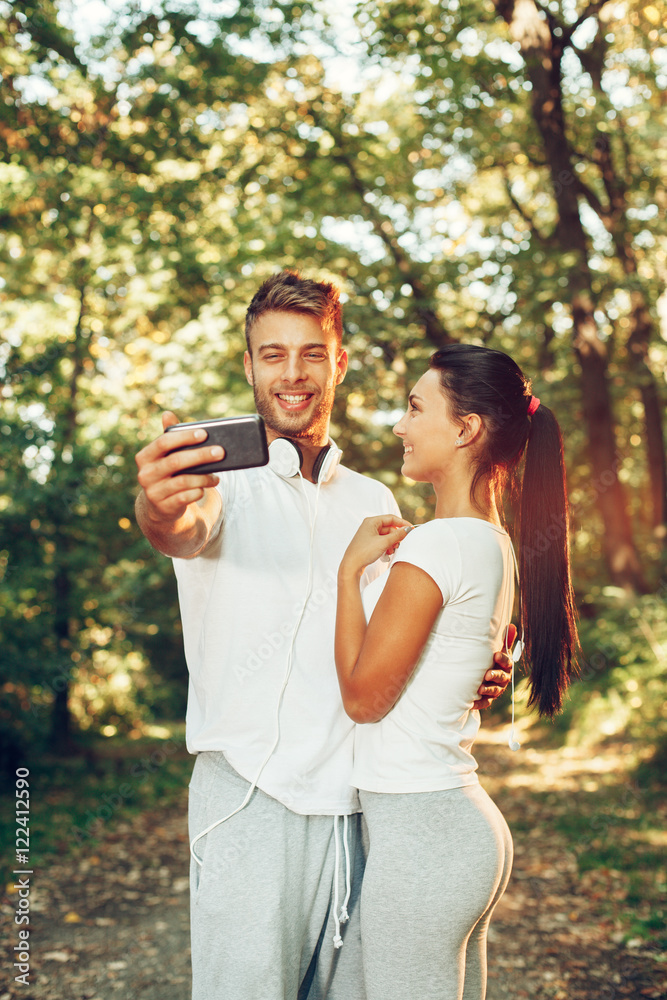 Fototapeta premium Young happy couple taking selfie in the park