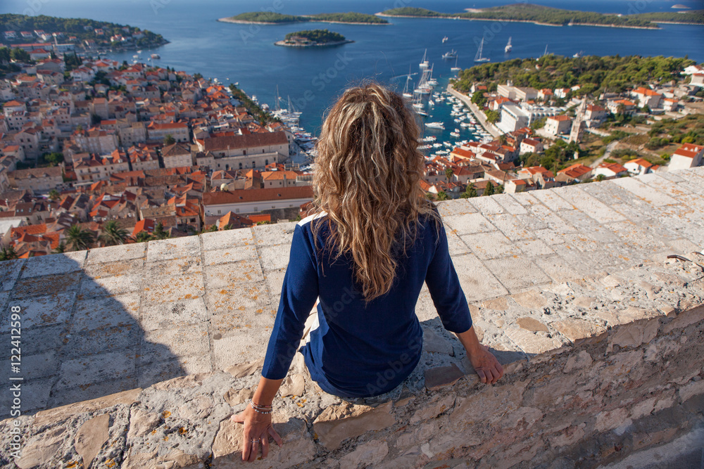 Fototapeta premium Woman looking the harbor of Hvar town, Croatia