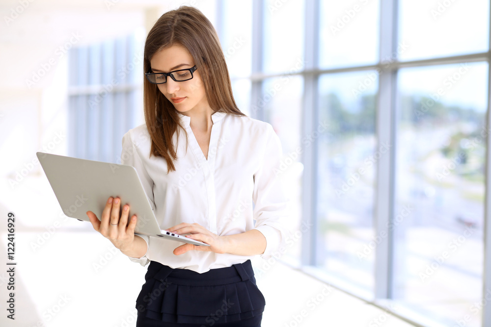 Portrait of modern business woman working with laptop computer in the office, copy space area Portrait of modern business woman working with laptop computer in the office, copy space area