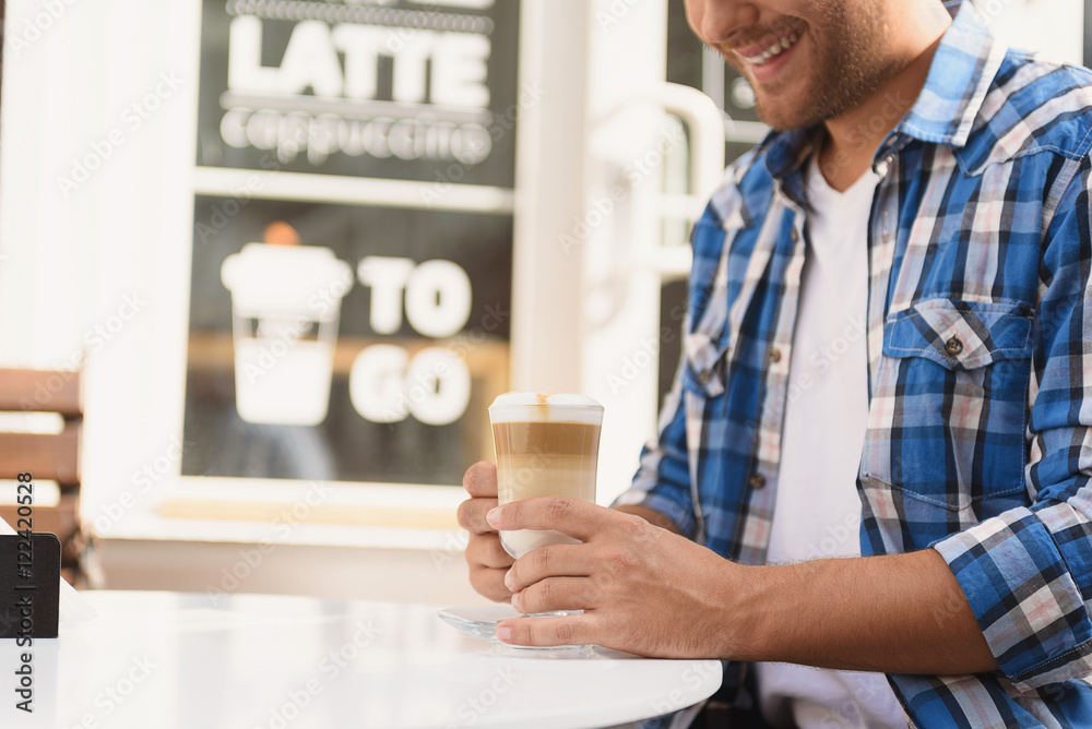 Handsome man relaxing with cup of latte