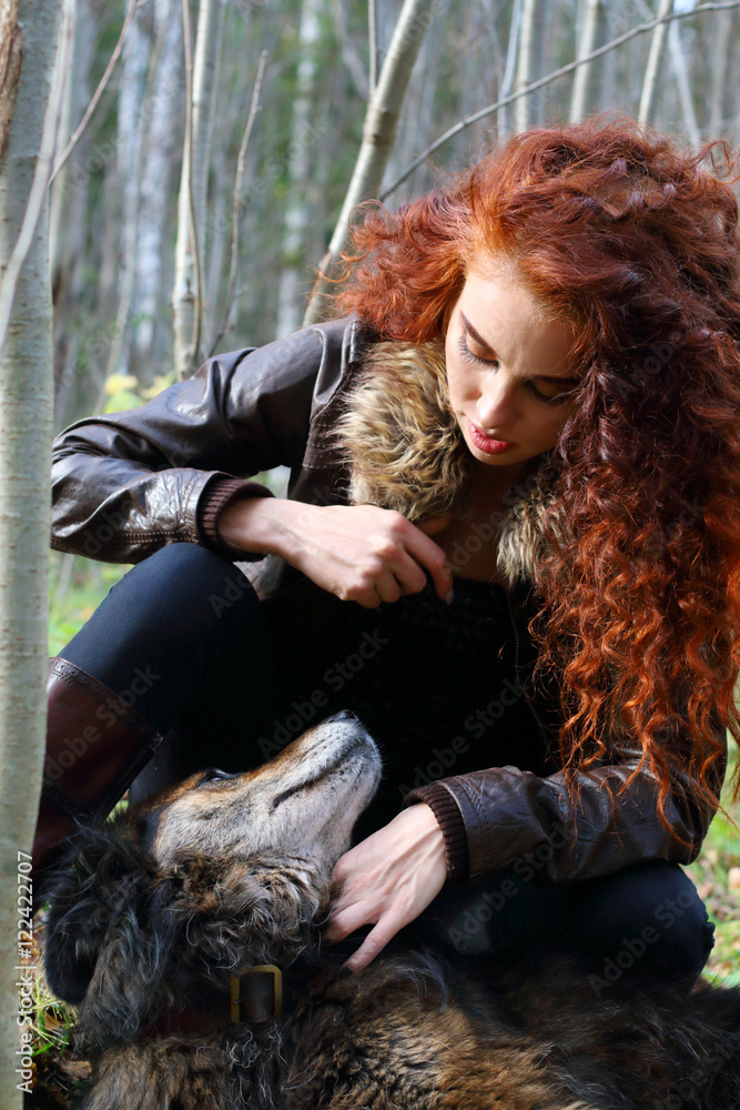 Beautiful girl in boots and jacket plays with dog in sunny autum