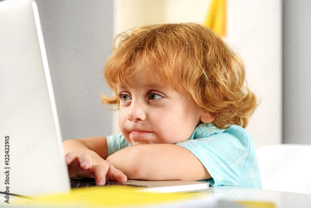 smiling redhead boy playing with computer smiling redhead boy playing with computer