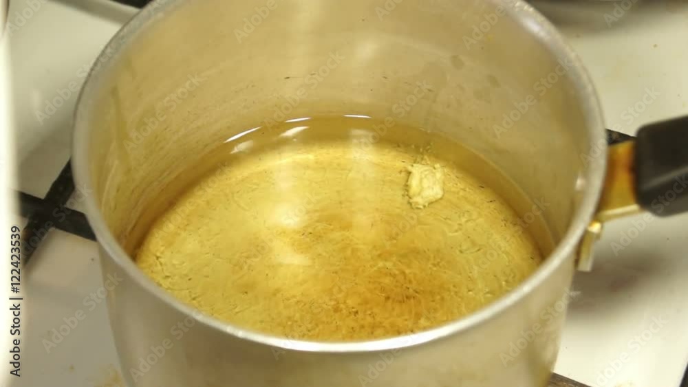 Somebody throws a small piece of dough to see if the oil warmed