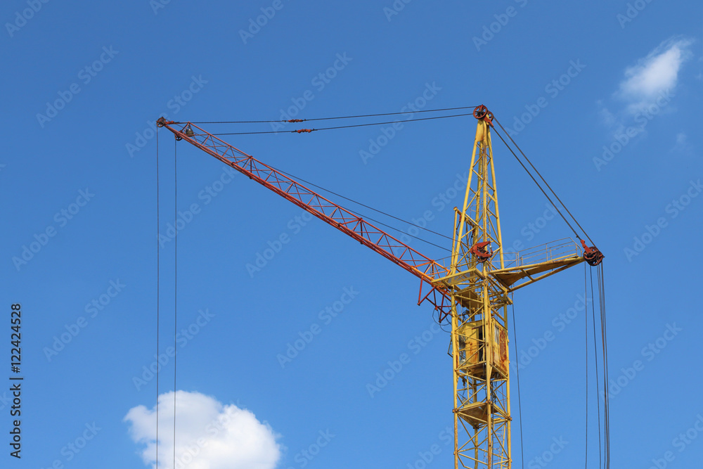 Part of stationary hoist on construction site, blue sky and whit