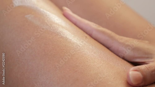 Female applying body cream on tanned legs with hands 4K 2160p 30fps UHD footage - Close-up woman health care with milky lotion on skin 3840X2160 UltraHD video 