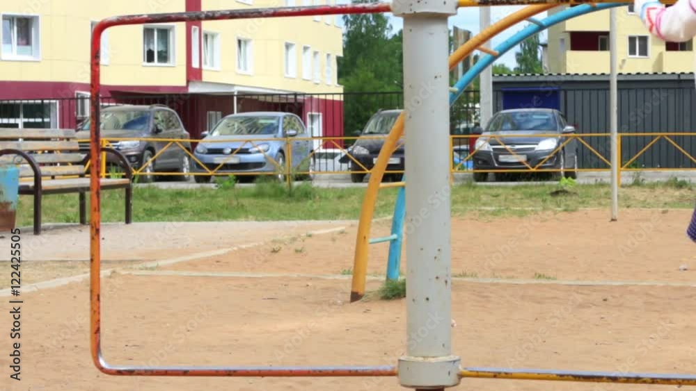 Llittle girl in dress plays on children playground at summer day Llittle girl in dress plays on children playground at summer day