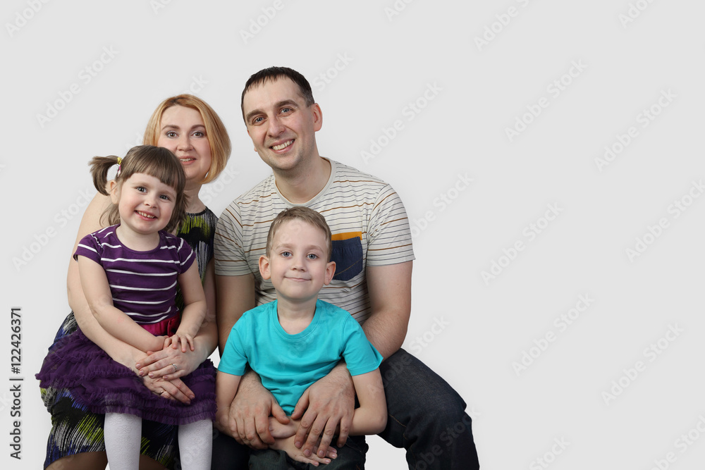 Full family portrait on gray background with copy space for text - Man, woman, boy and girl - happy parenthood