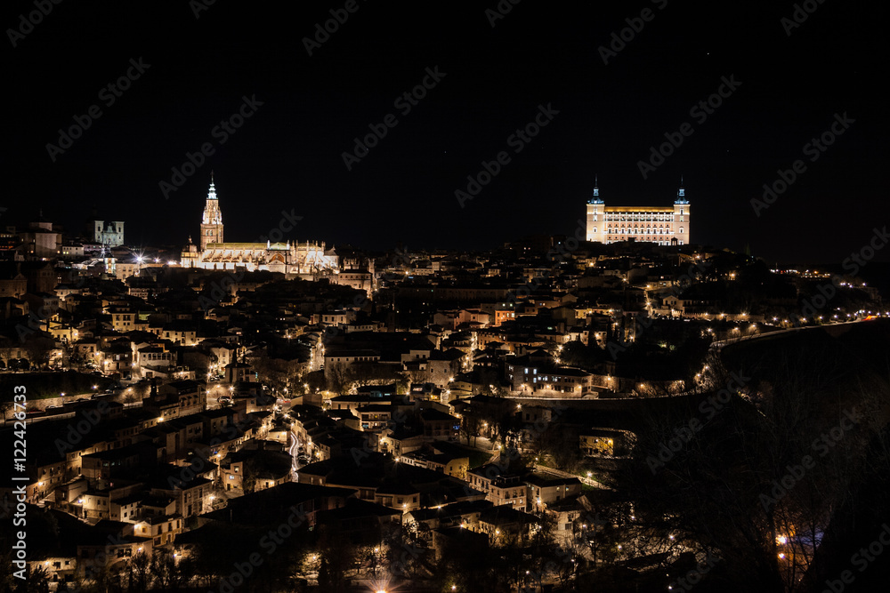 Naklejka premium Vista nocturna de Toledo con el Alcazar y la catedral de Santa María al fondo