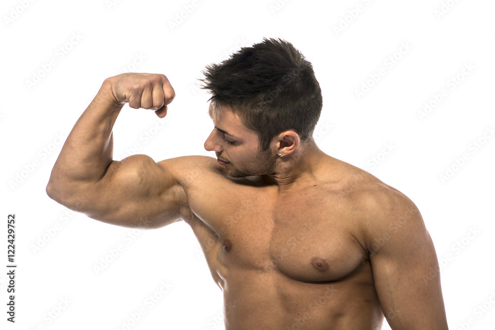Muscular shirtless young man flexing and looking at his own bicep, isolated on white