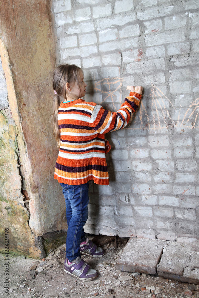 Girl draws with chalk on brick wall Girl draws with chalk on brick wall