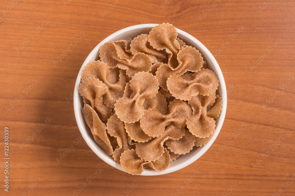 Wholegrain Farfalle into a bowl. wholemeal. Integral. Wholegrain Farfalle into a bowl. wholemeal. Integral.