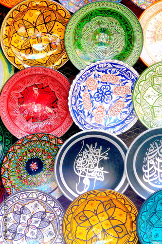 Traditional colorful Moroccan faience pottery dishes in a typical ancient shop in the Medina's souk of hte ancient imperial city of Marrakech, Morocco.
