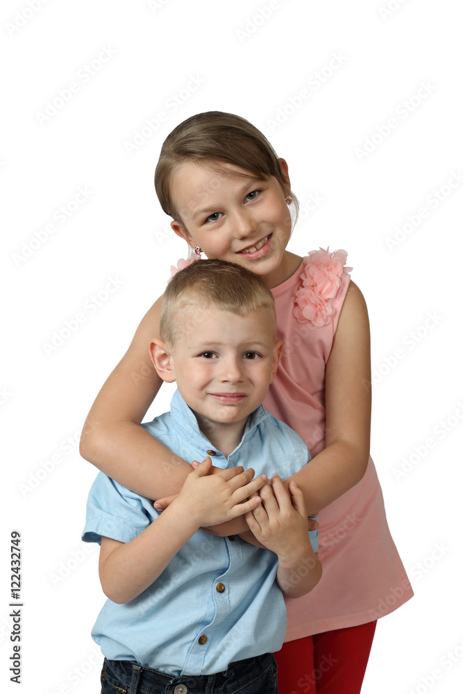 Little boy and older girl stand embraced isolated on white background - love and friendship concept Little boy and older girl stand embraced isolated on white background - love and friendship concept