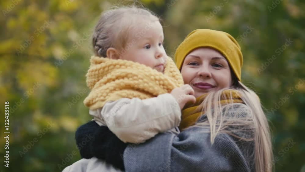 Mother and her daughter little girl playing in a autumn park - mommy and child have fun and spinning, close up Mother and her daughter little girl playing in a autumn park - mommy and child have fun and spinning, close up