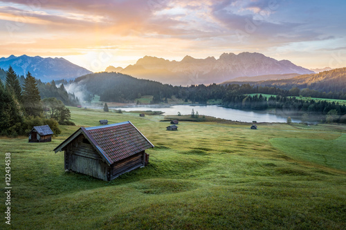Fotografia, Obraz View over Geroldsee with wooden hut and Karwendel mountains at early morning, Ba