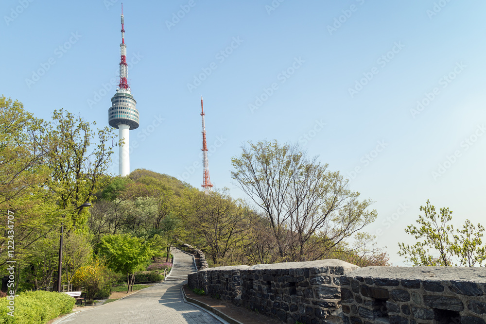 Walkway, old fortress wall (or City Wall) and N Seoul Tower at the Namsan Hill (or Namsan Park or Namsan Mountain) in Seoul, South Korea.