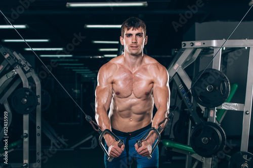 handsome bodybuilder works out pushing up excercise in gym