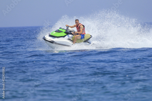 Obraz na płótnie Tourists enjoy driving jetski on the ocean w salonie