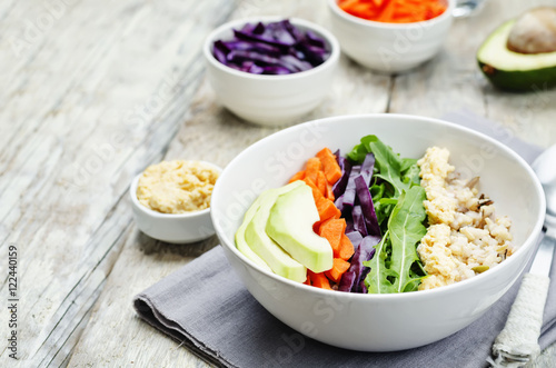 Rice bowl with red cabbage  carrots  avocado  arugula and hummus