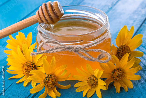 Honey in a glass jar with flowers