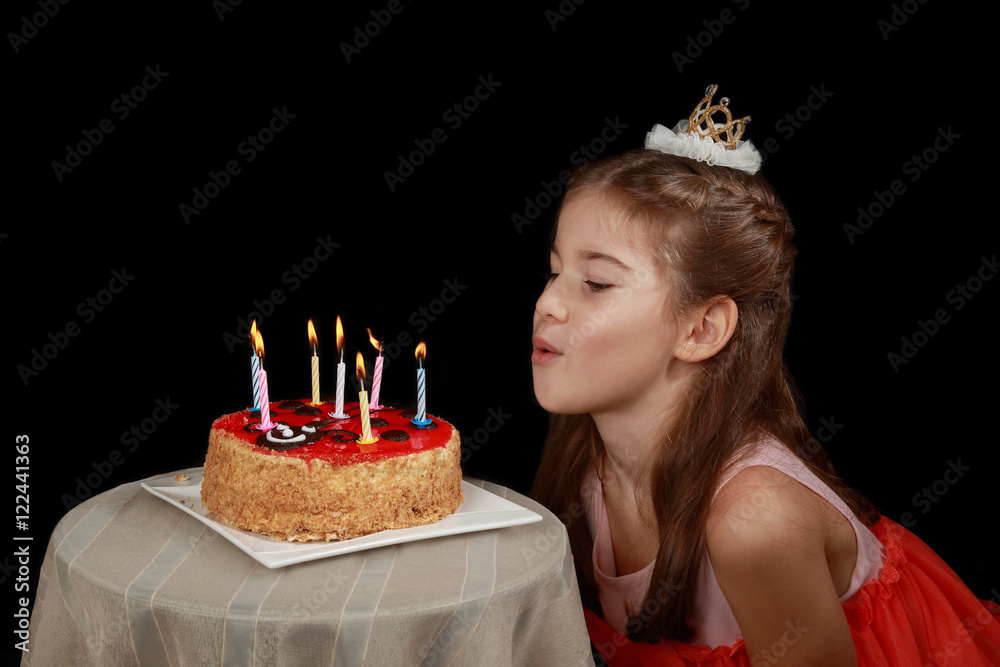 Princess anniversary - cute girl in red dress and crown on head going to blow  out the candles on birthday cake - low key side view on black background  Stock Photo | Adobe Stock