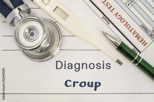 Diagnosis Croup. Stethoscope, electronic thermometer, patient blood test results lying on medical history, which is written diagnosis Croup. Concept for internal medicine, ENT