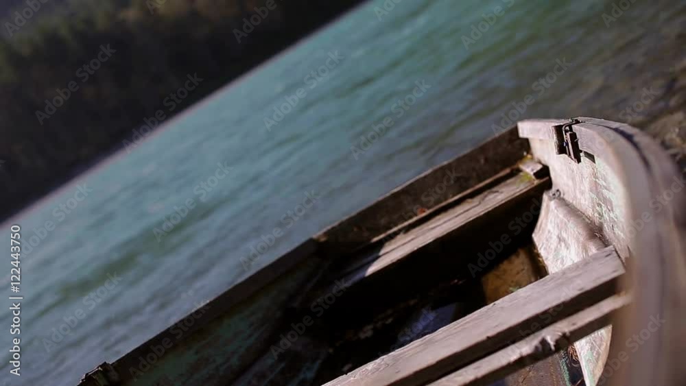 old wooden boat is on the shore of a mountain river