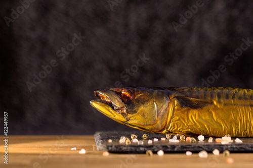 Fototapeta Naklejka Na Ścianę i Meble -  Smoked mackerel background. Smoked mackerel on slate board, top view. Smoked fish with onion, tomato and pepper. Food background.