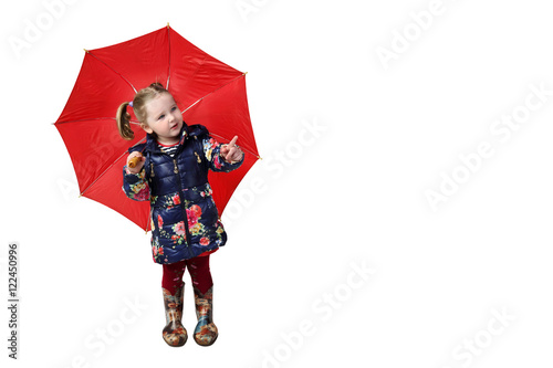 Little girl in rubber boots stands under red umbrella and shows finger isolated on white background with blank copy space on right - weather and rain concept