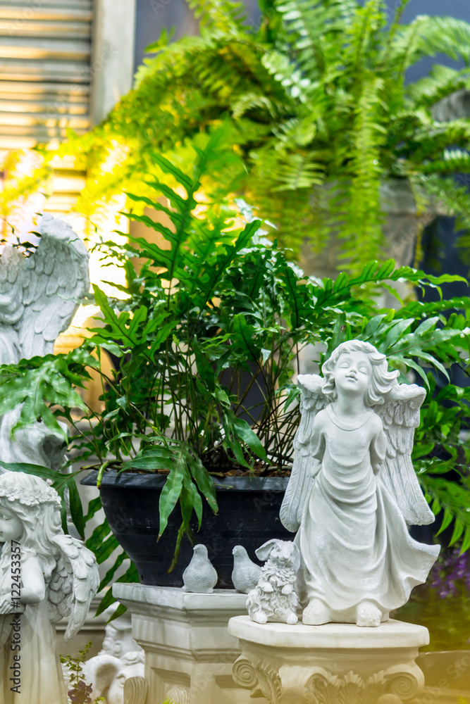 Statue of Cupid in cozy garden./ Statue Cupid and waterfall in cozy garden on summer.
Statue of Cupid in cozy garden./ Statue Cupid and waterfall in cozy garden on summer.