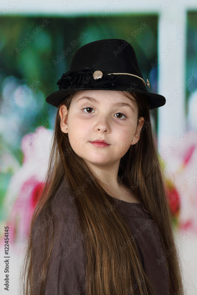 Cute long haired plump round faced girl in hat portrait - children beauty and fashion concept Cute long haired plump round faced girl in hat portrait - children beauty and fashion concept