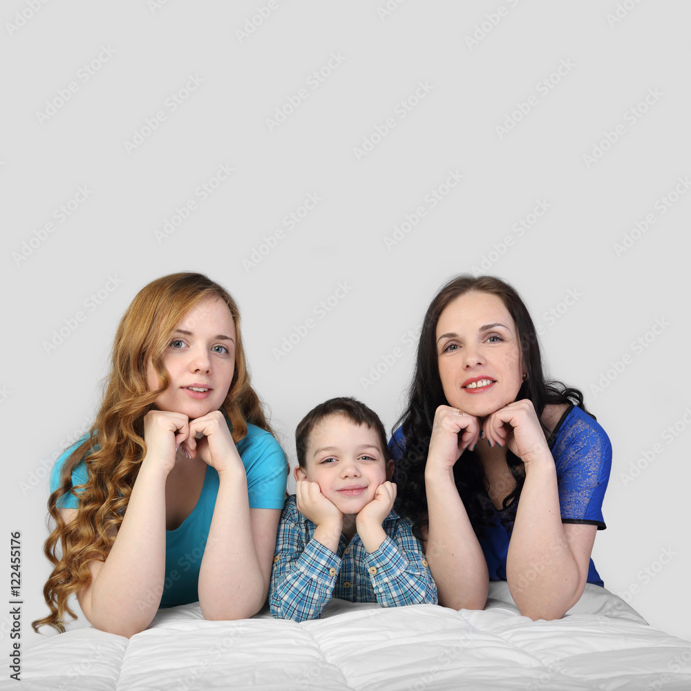Woman, girl and little boy lie on white blanket on gray background in square with copy space for text - incomplete family Woman, girl and little boy lie on white blanket on gray background in square with copy space for text - incomplete family