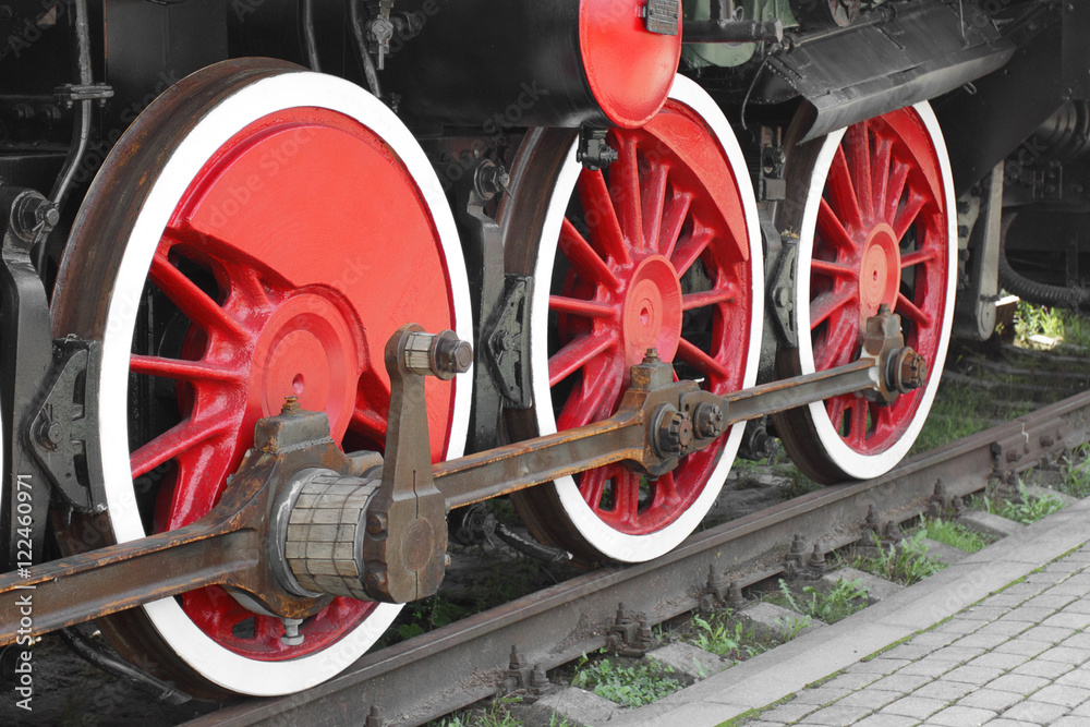 Wheels of steam locomotive on rails closeup shot at an angle